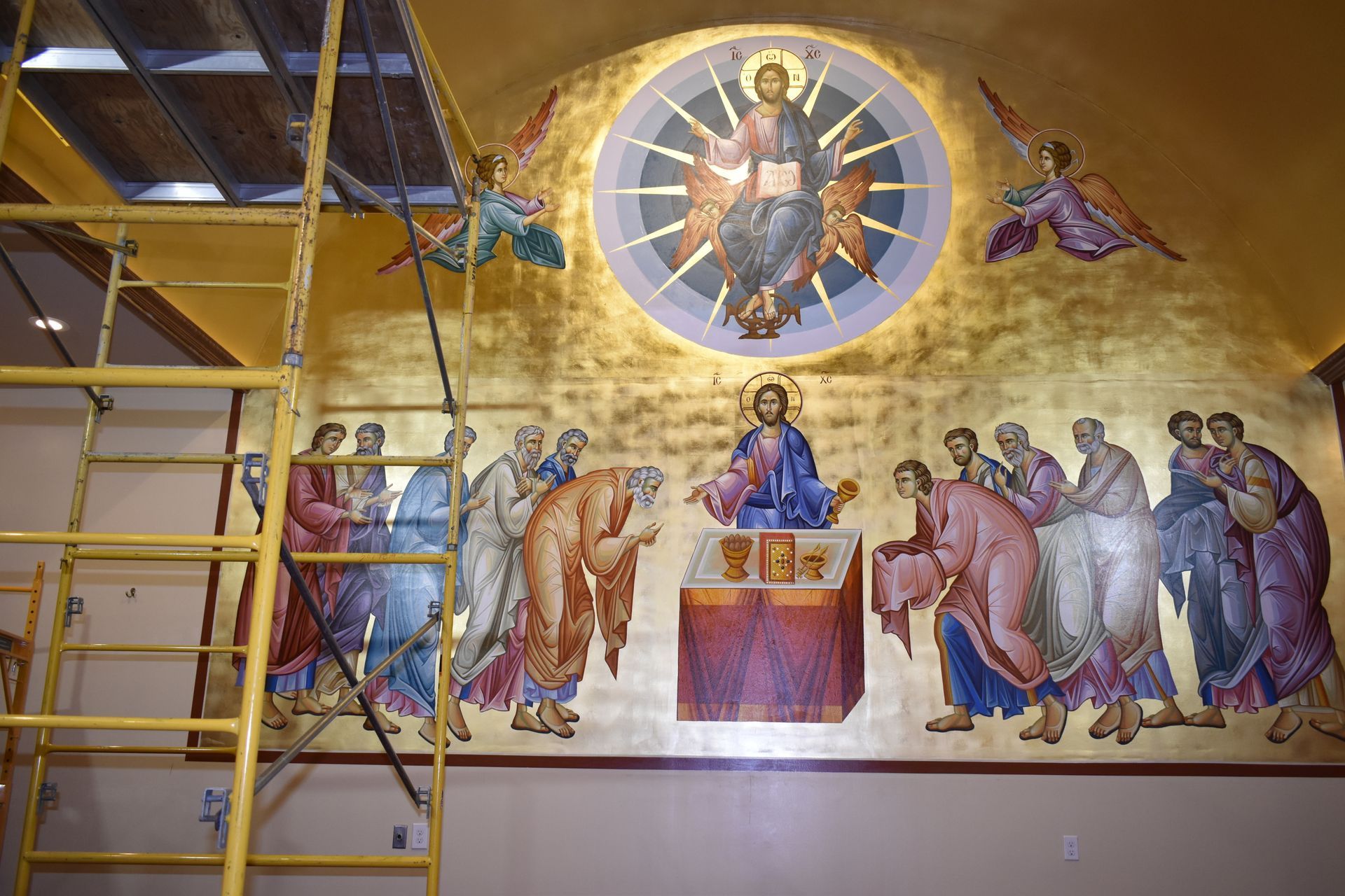 A painting of jesus is being painted on a wall in a church
