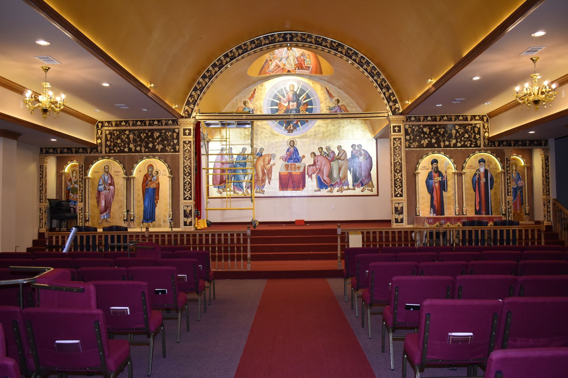 A church with purple chairs and a large painting on the wall