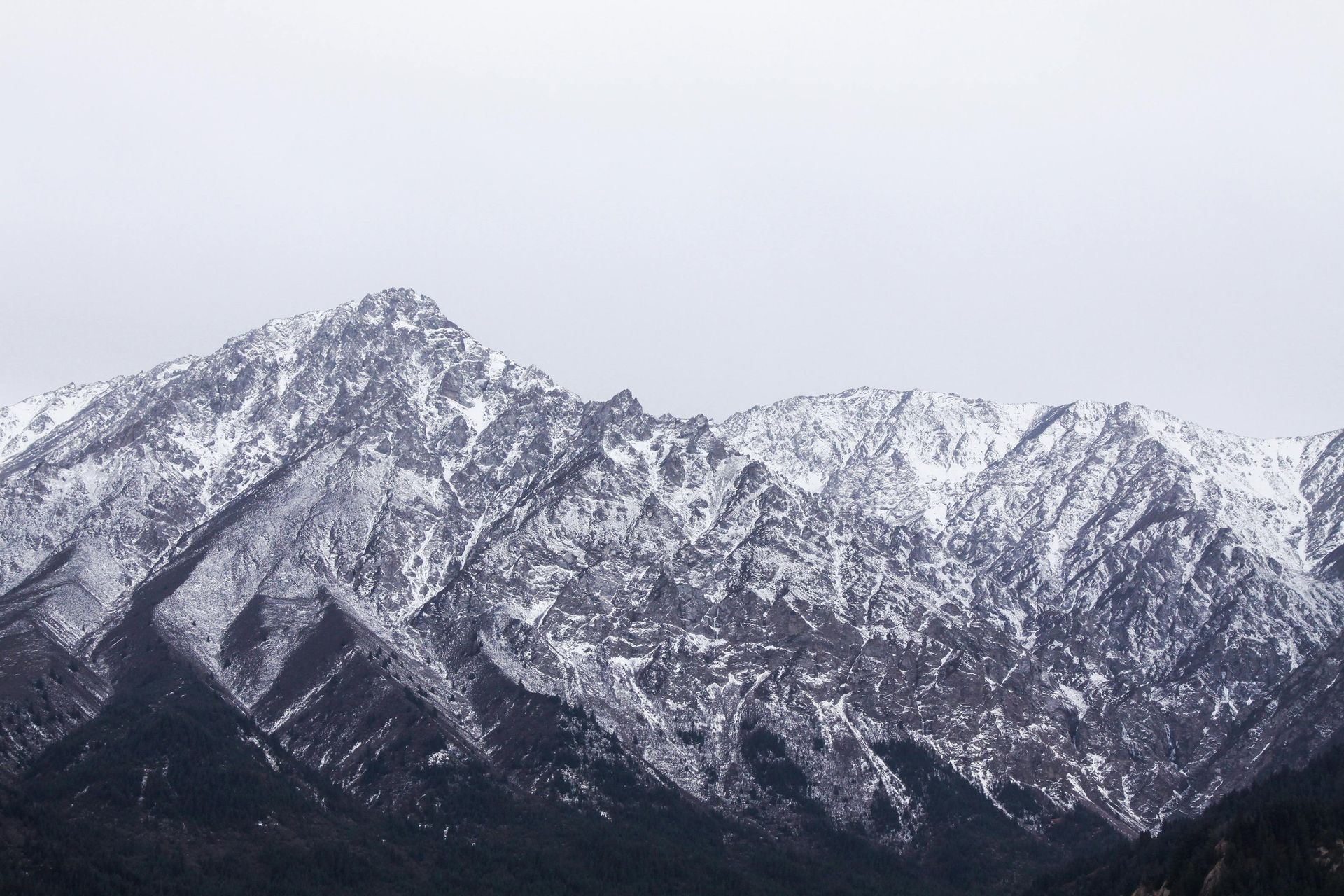 Snow-covered mountain range under a gray sky.