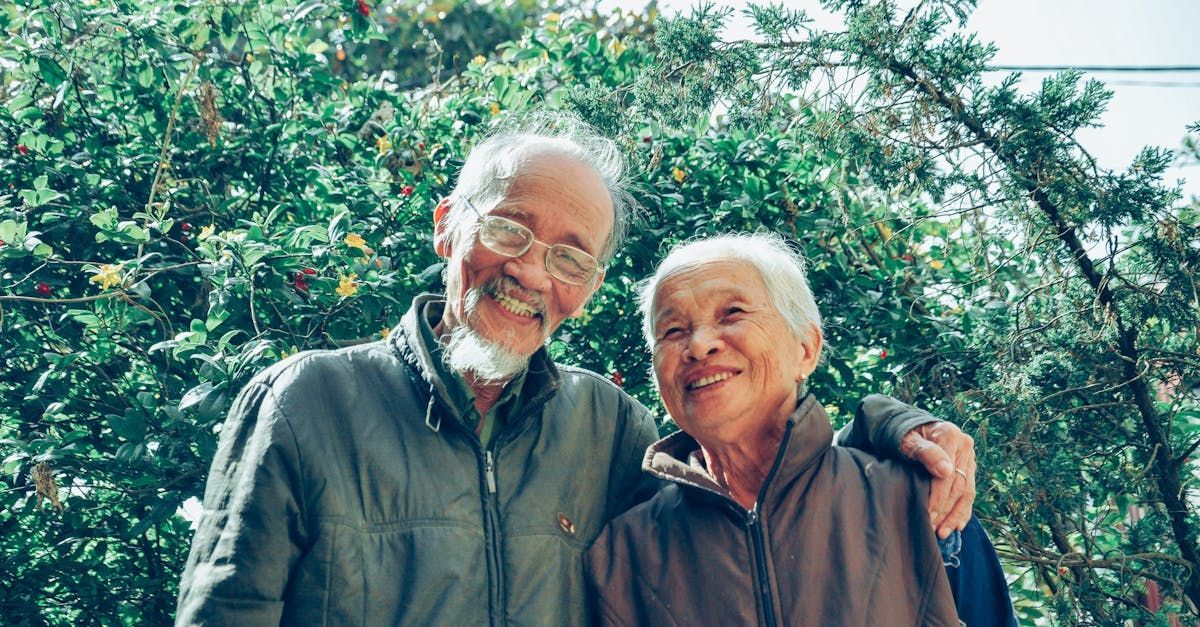 A man and a woman are posing for a picture in front of trees.