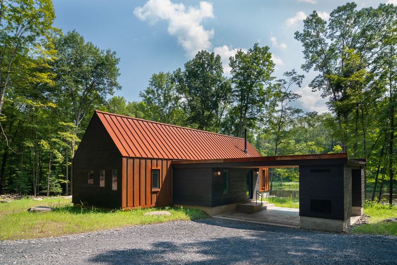 A house with a red roof is surrounded by trees