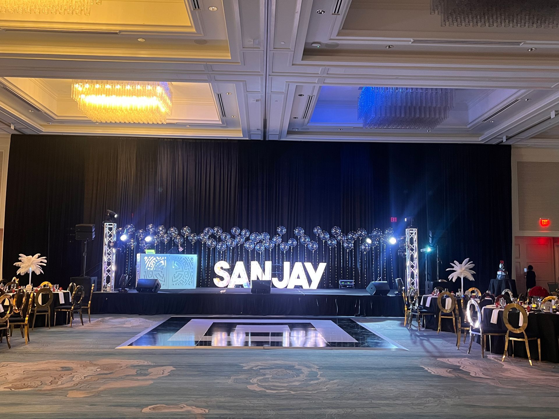 A ballroom with a stage featuring illuminated 