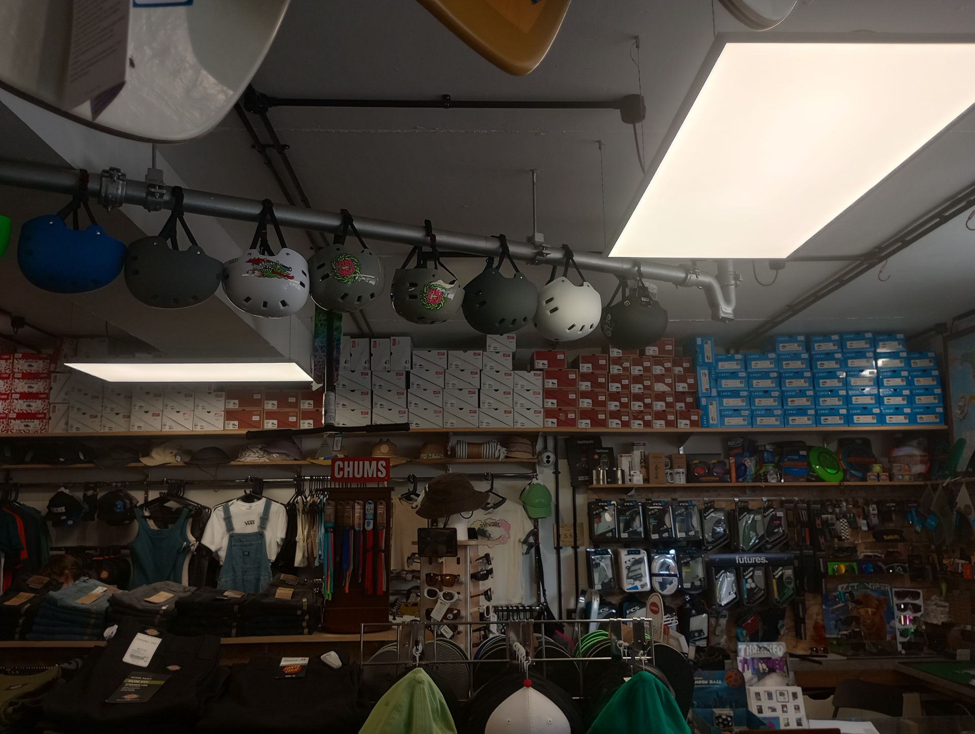 A bunch of helmets are hanging from the ceiling in a store