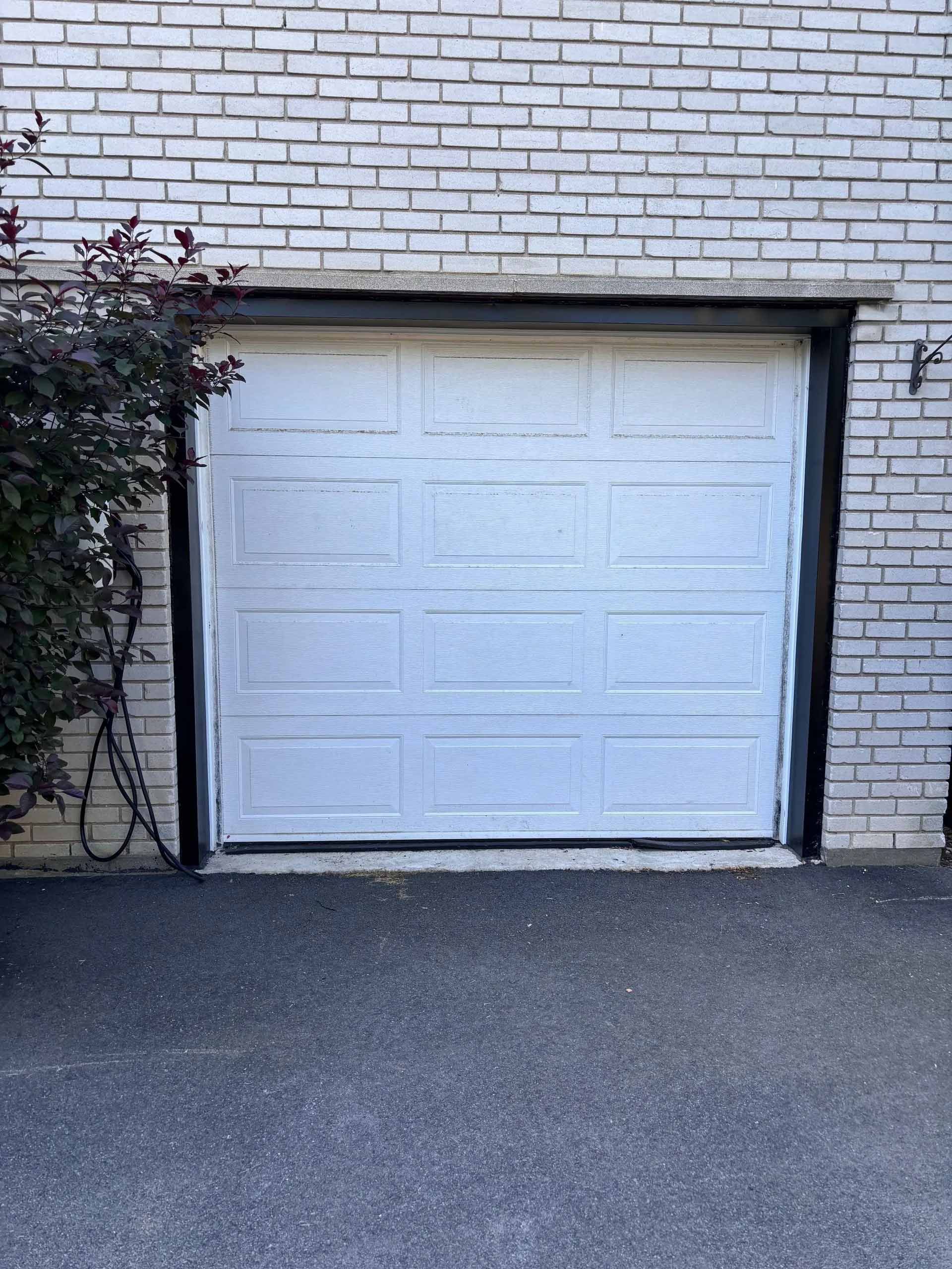 Une porte de garage bleue se trouve sur un bâtiment en briques.