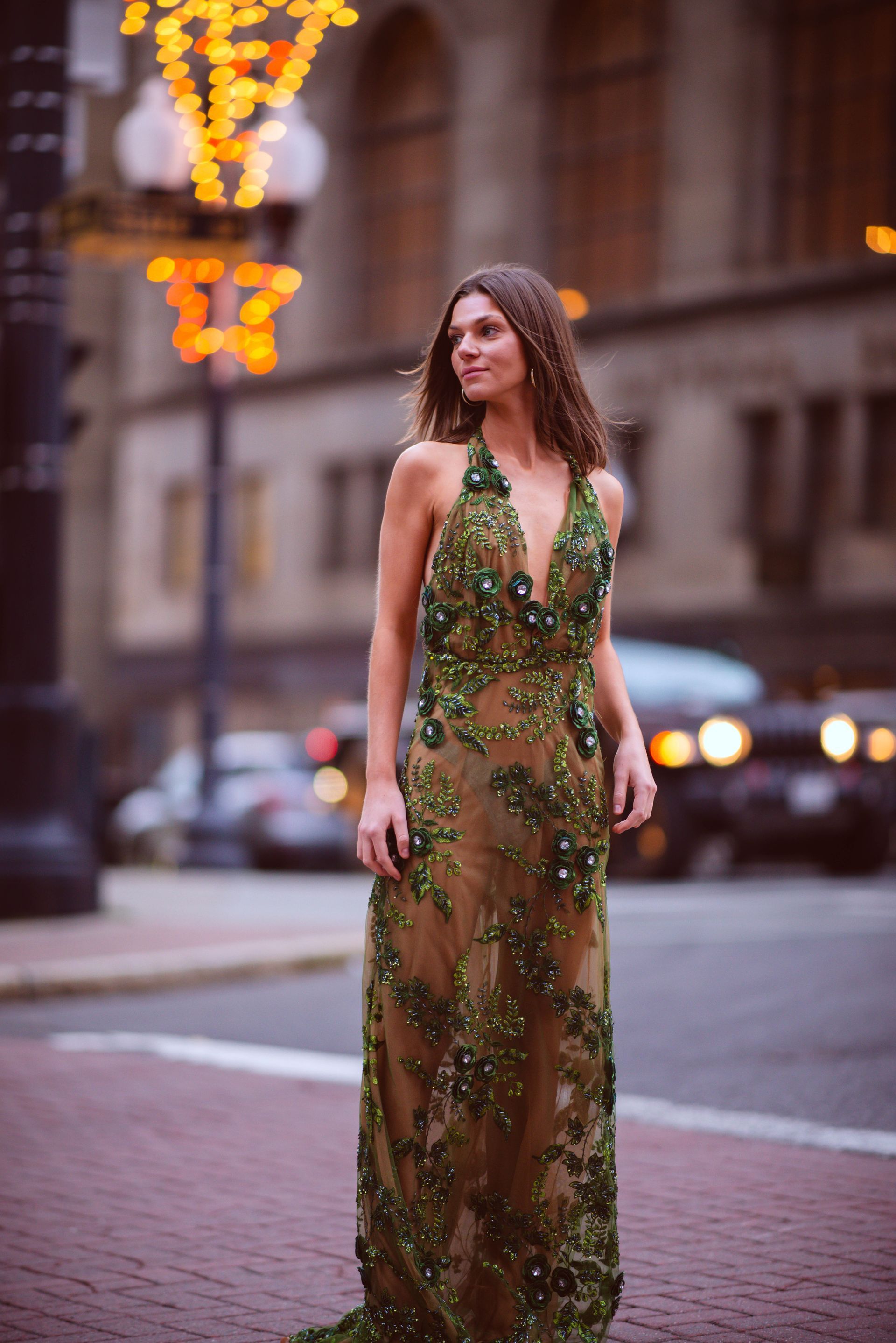 Woman in black and white flowing dress, walking down a cobblestone street.
