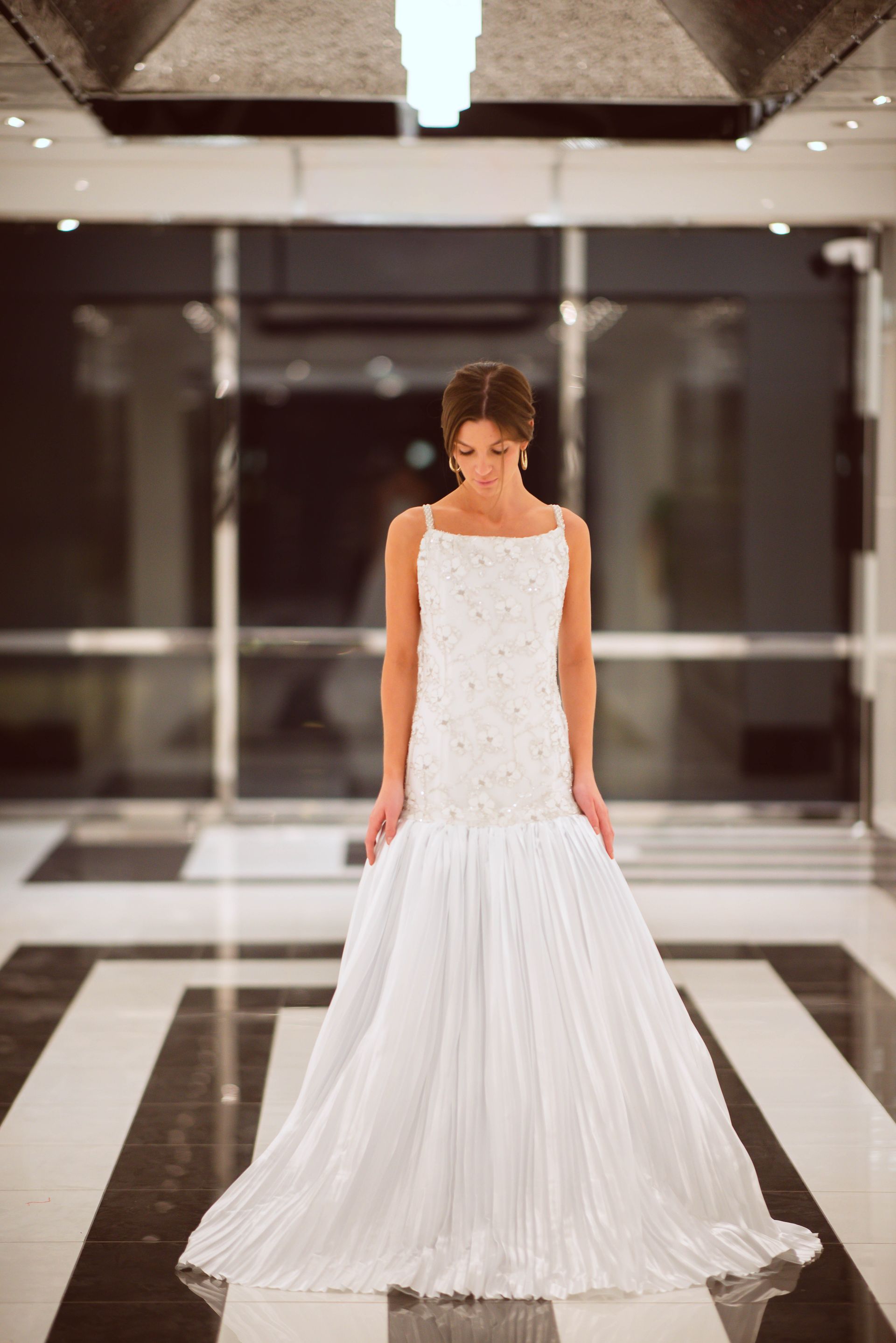Woman in black and white patterned coat, turning back to look at the camera