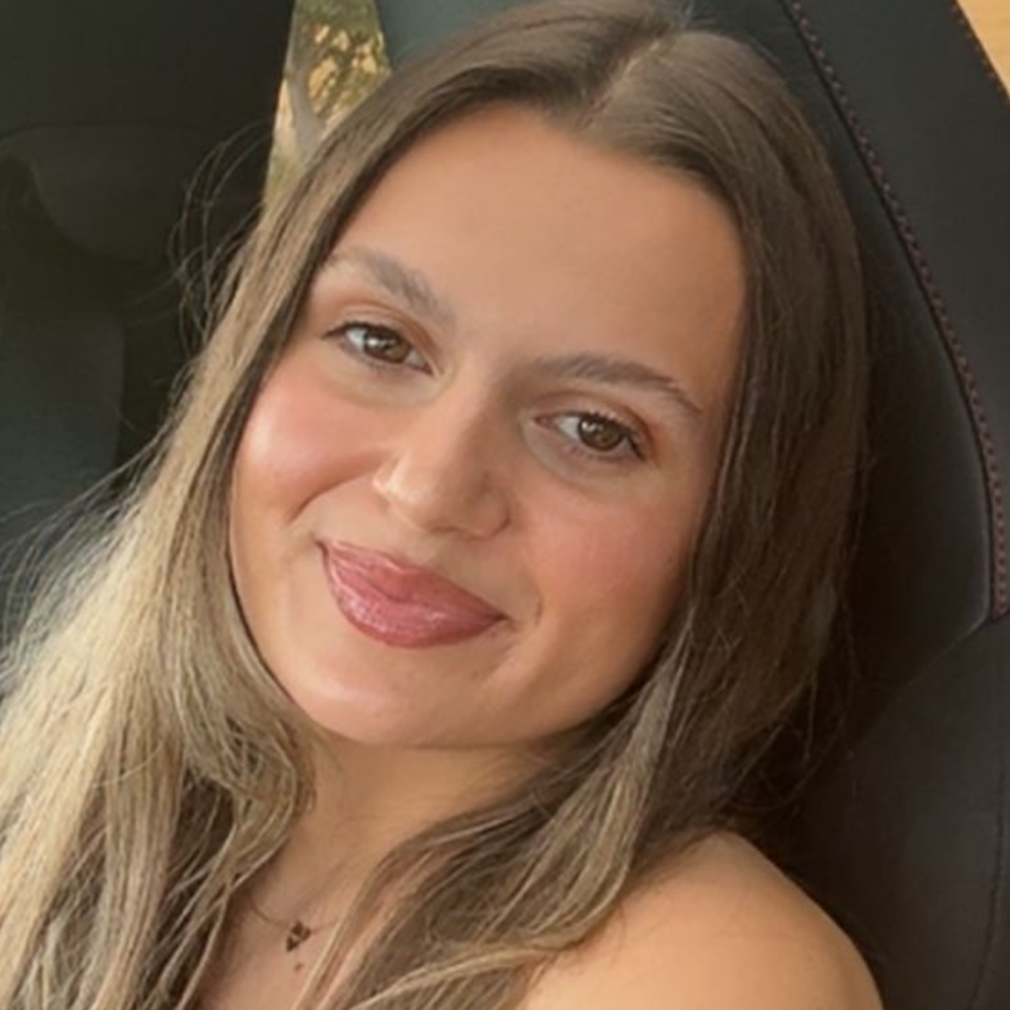 A man wearing glasses and a patterned shirt is smiling for the camera.