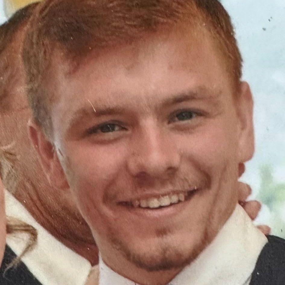 A man in a suit and tie is smiling for the camera.