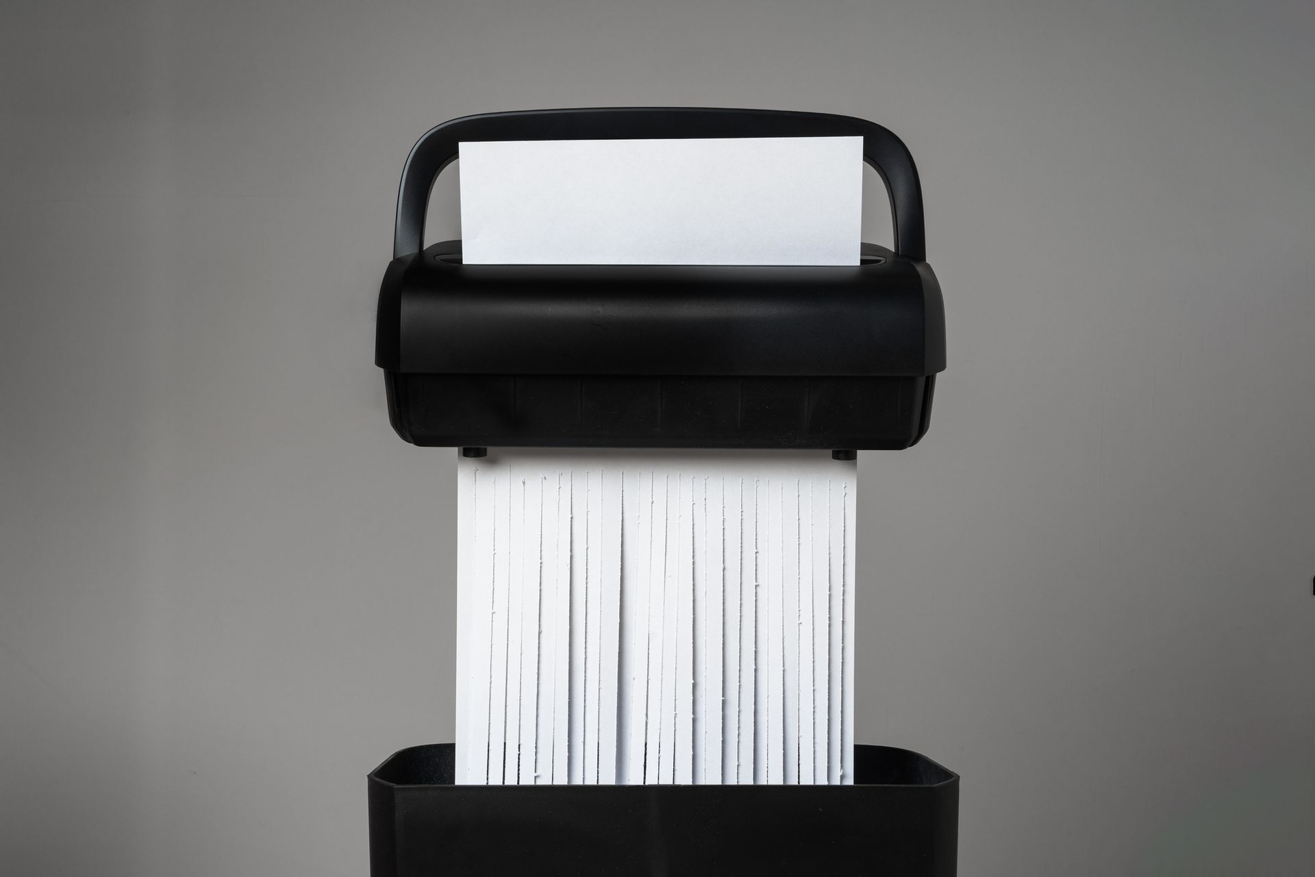 Black paper shredder cutting paper on gray background close up | Indianapolis IN Black paper shredder cutting paper on gray background close up | Indianapolis IN