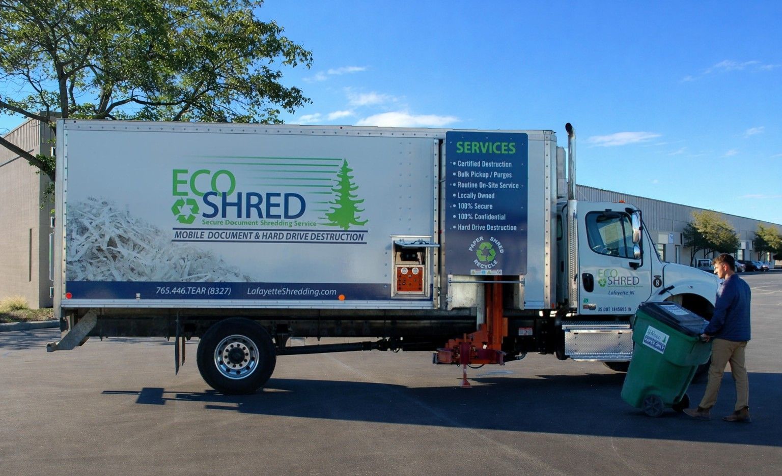 Eco Shred truck with technician wheeling a security tote for on-site shredding. 