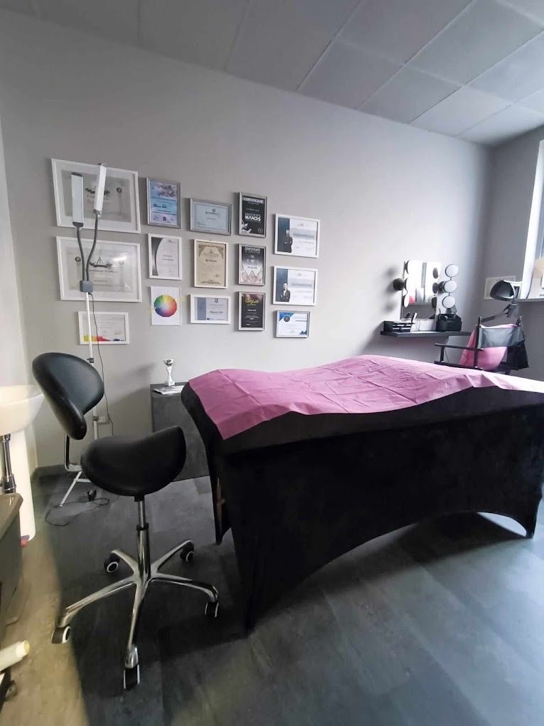 Sala trattamenti con lettino per massaggi, sgabello, premi alla parete.