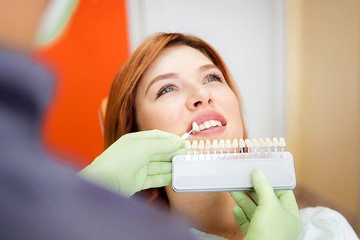 woman with dentist and tooth whitening samples