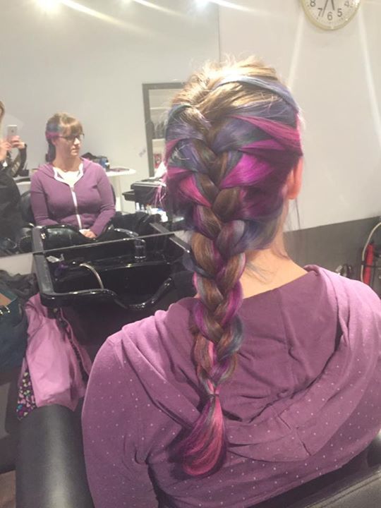 A woman with braided hair is sitting in a chair in front of a sink