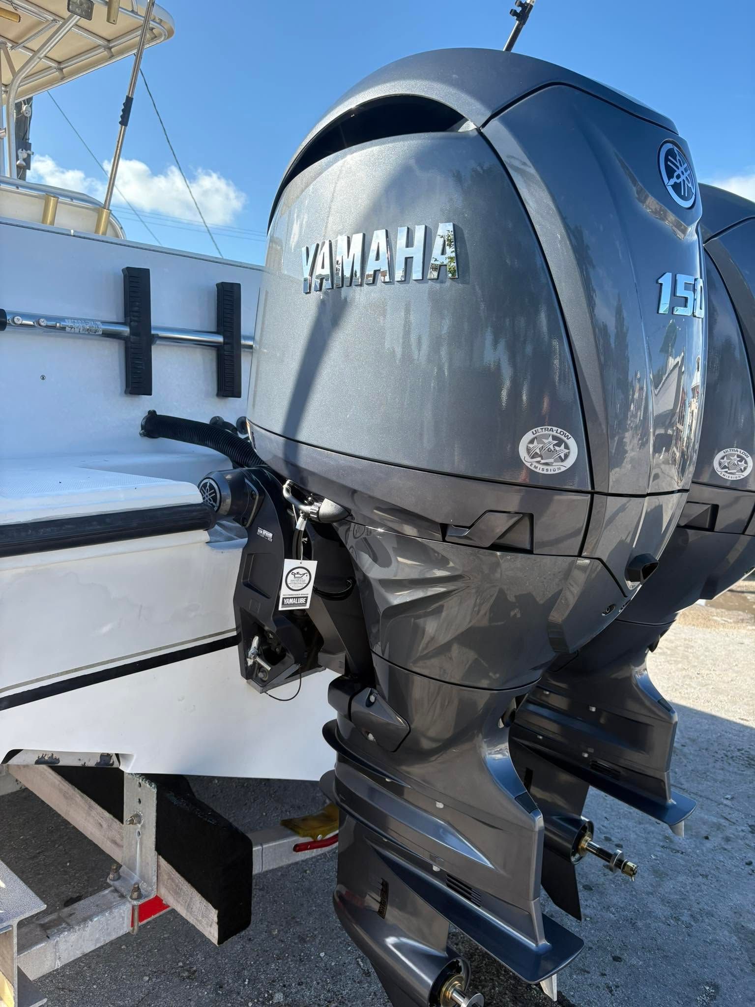 Close-up of a black Yamaha outboard motor mounted on a boat in bright sunlight.