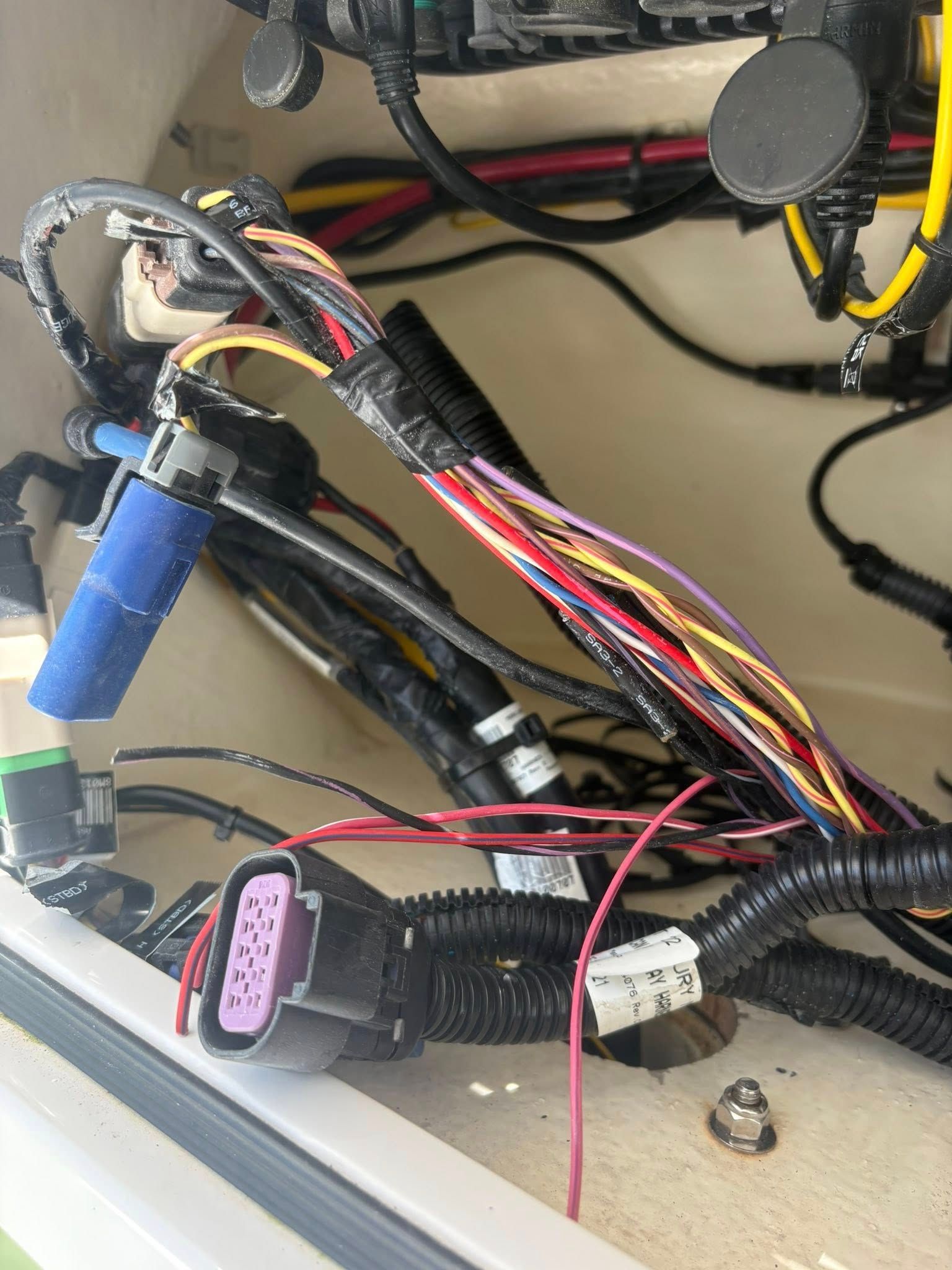 Wiring harness with multicolored cables and connectors inside an open equipment enclosure