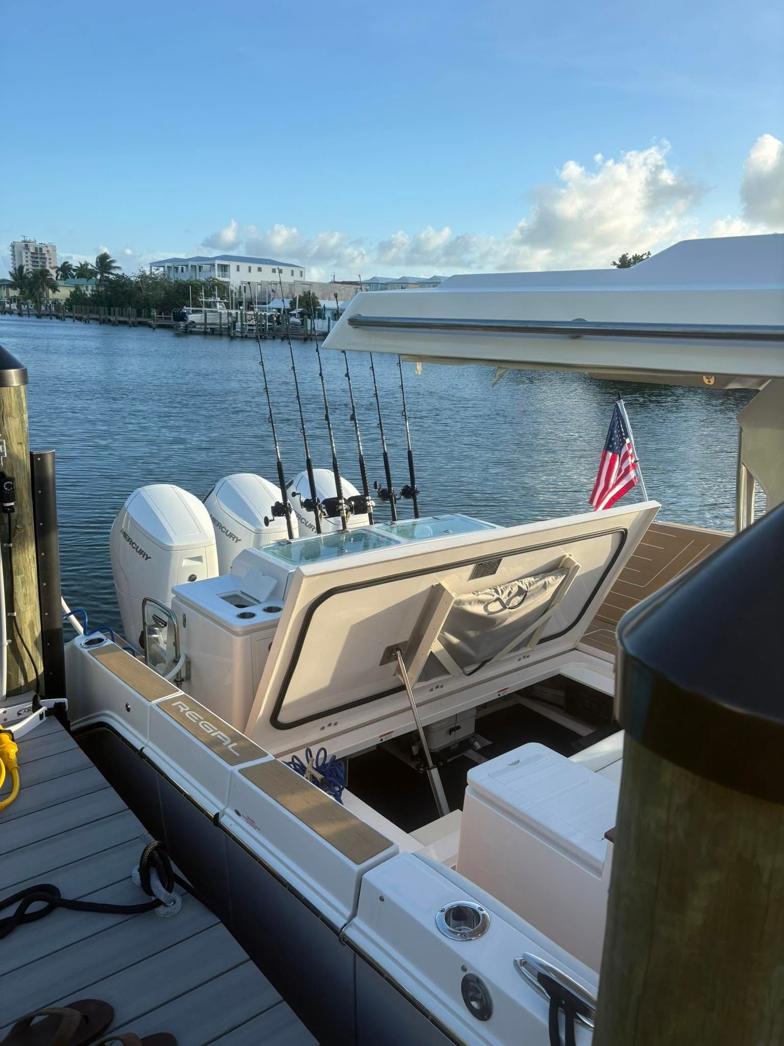Fishing boat stern with rods and American flag on a calm waterfront at sunset