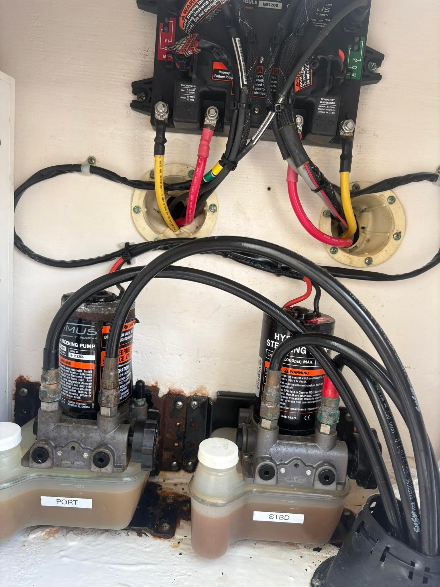 Close-up of electrical breaker panel wiring with circuit breakers, black cables, and red/yellow wires.