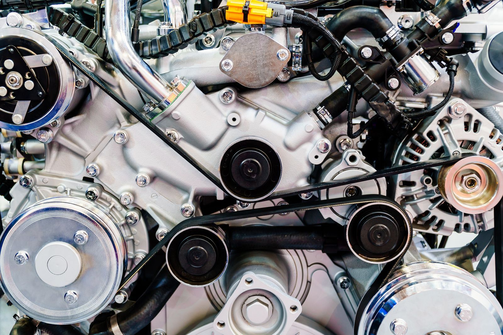 A close up of a car engine with a lot of gears and belts.