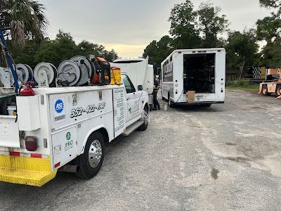 Two utility trucks are parked next to each other in a parking lot.