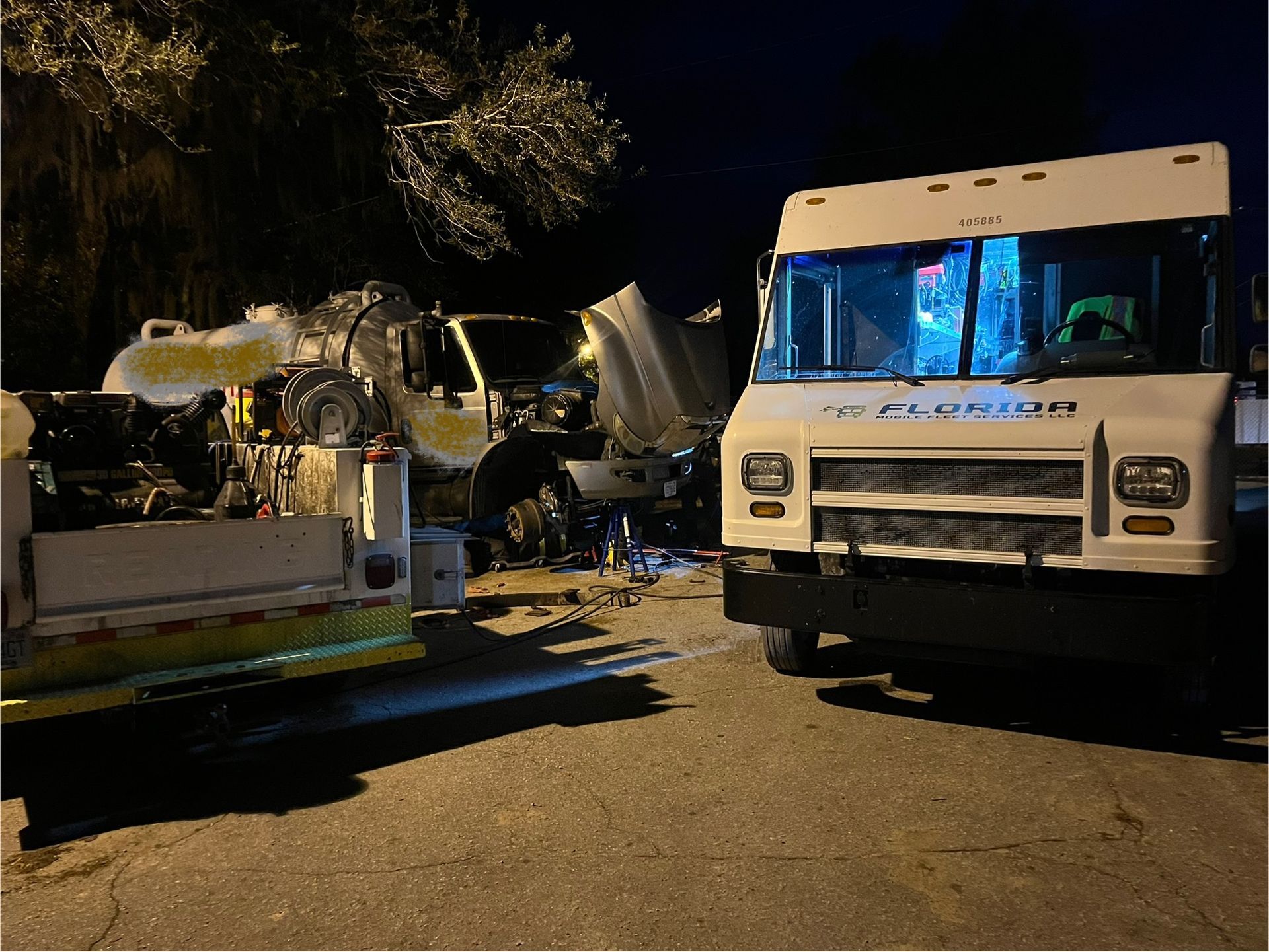 Two trucks are parked next to each other in a parking lot at night.