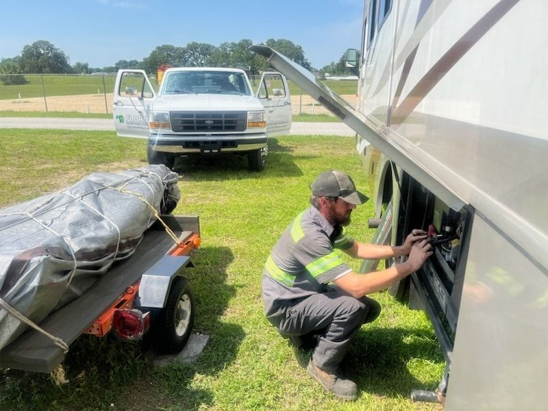 A man is working on the side of a rv.
