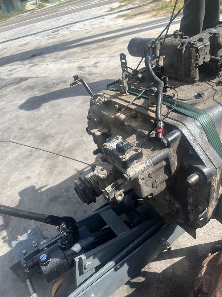 A tractor engine is sitting on the ground in a parking lot.
