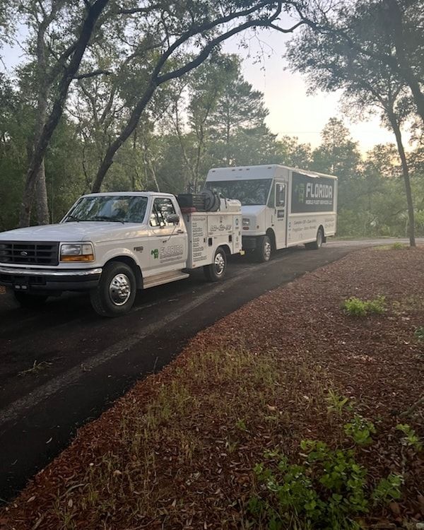 A tow truck and a bus are parked on the side of the road.