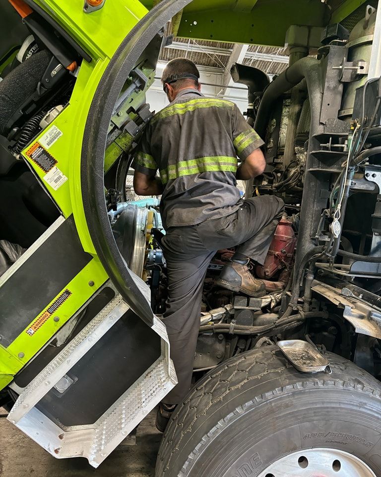 A man is working on the engine of a truck.