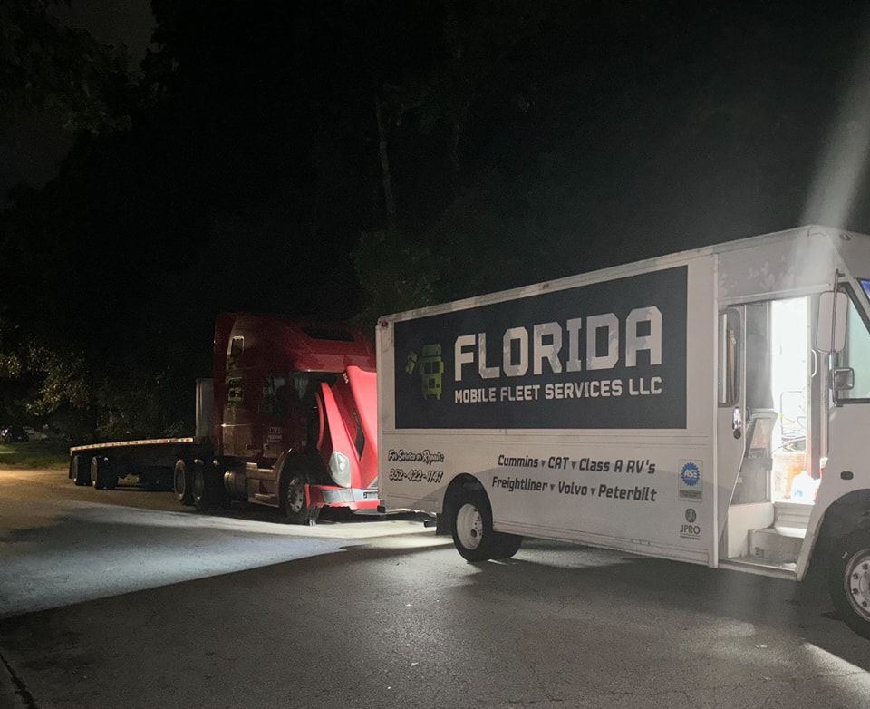 A florida mobile fleet services truck is parked on the side of the road at night.