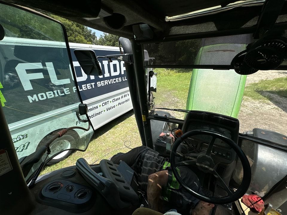 The inside of a tractor with a mobile fleet company van in the background.