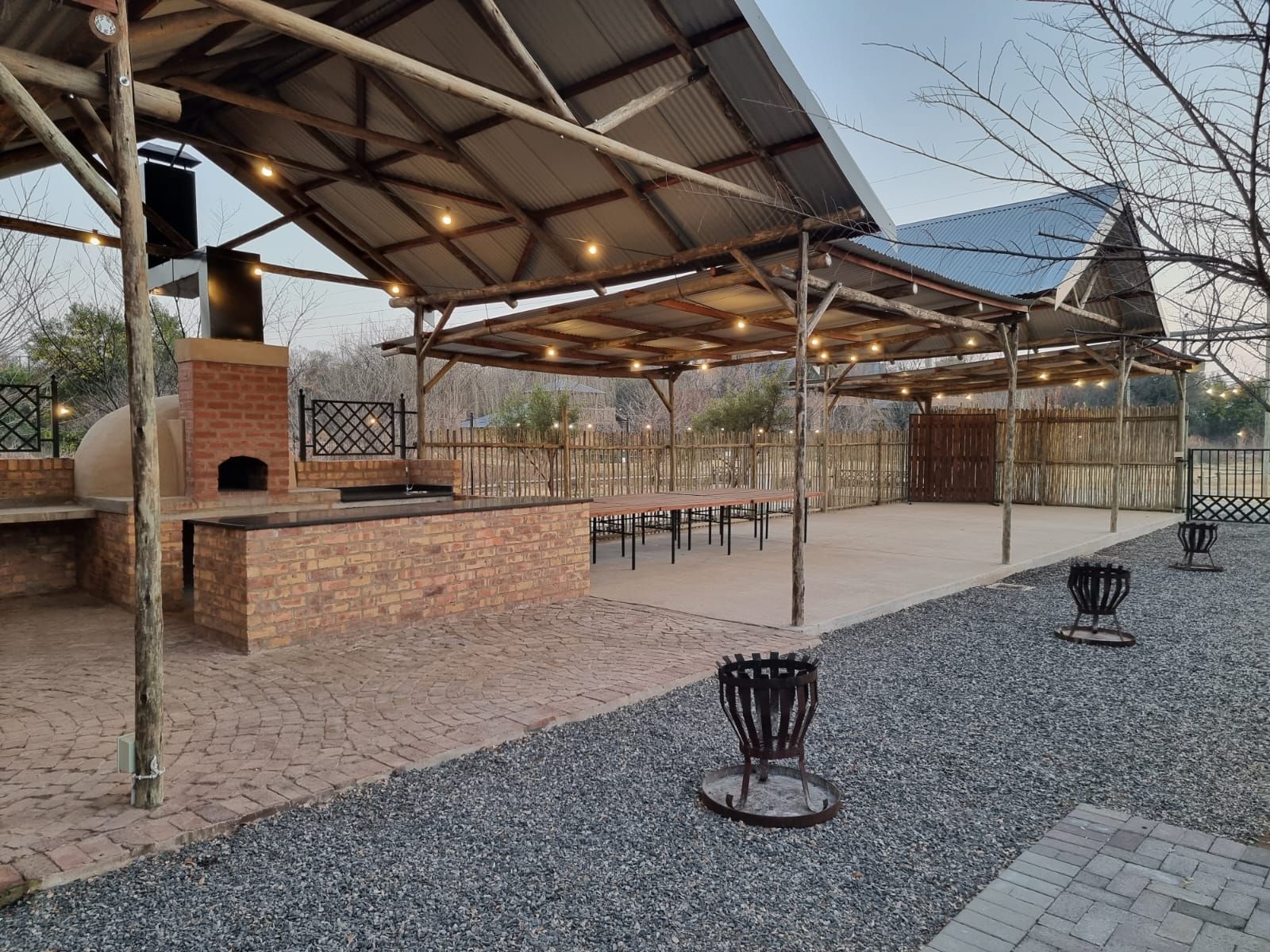 A large outdoor area with a brick oven and a covered area.