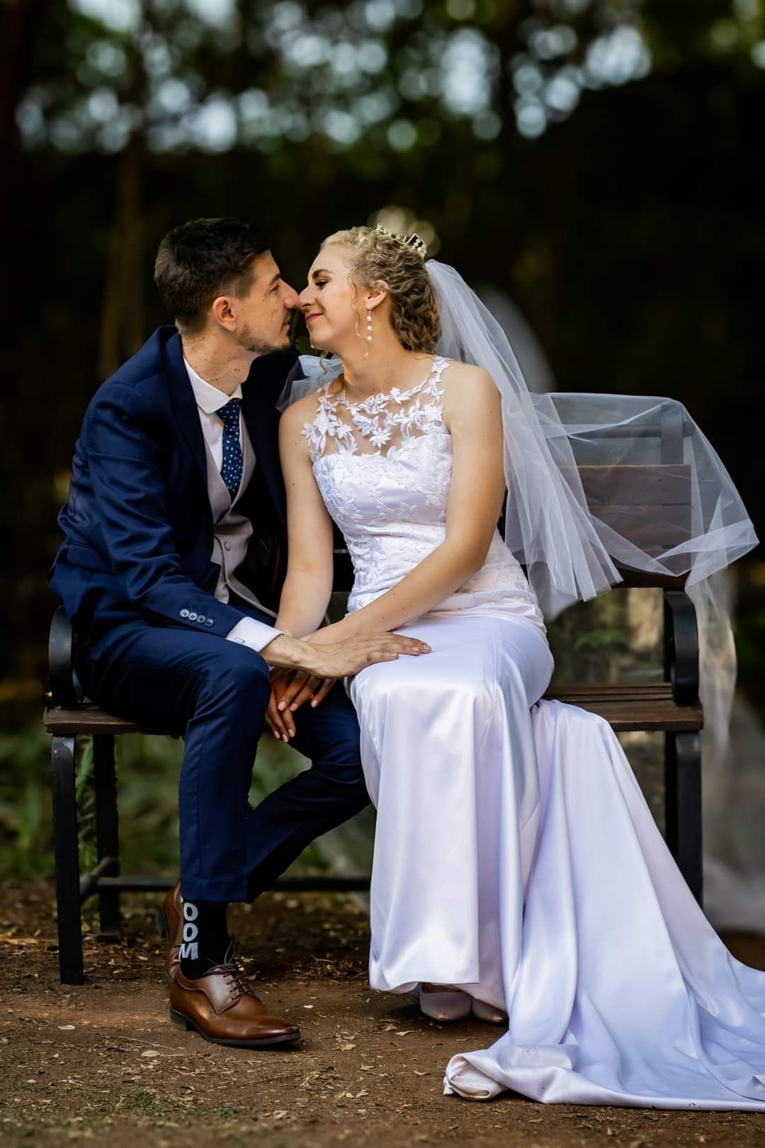 A bride and groom are sitting on a bench at Riverside Castle, Pretoria's premier wedding venue.