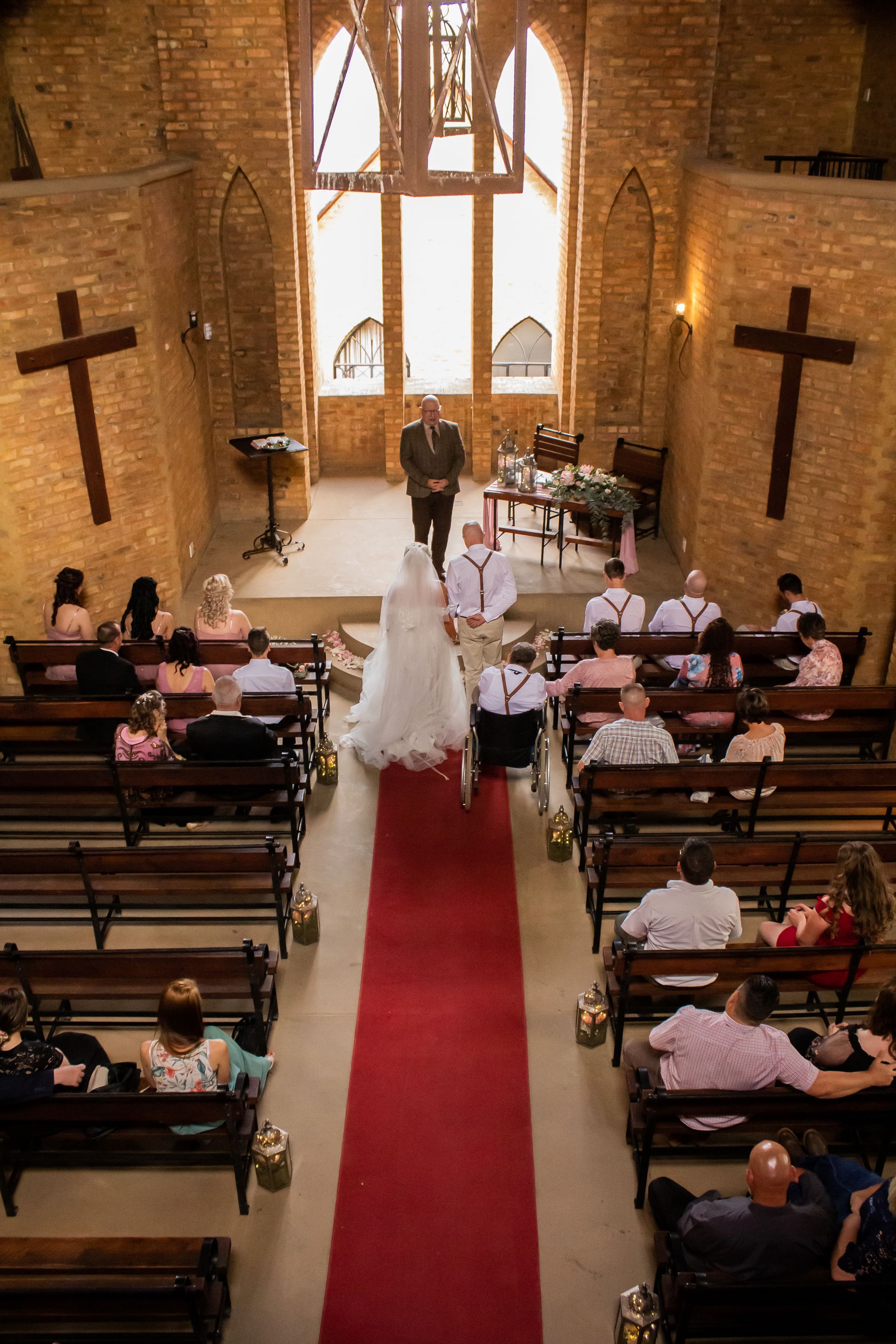 A bride and groom are walking down the aisle of the chapel at Riverside Castle in Pretoria East.