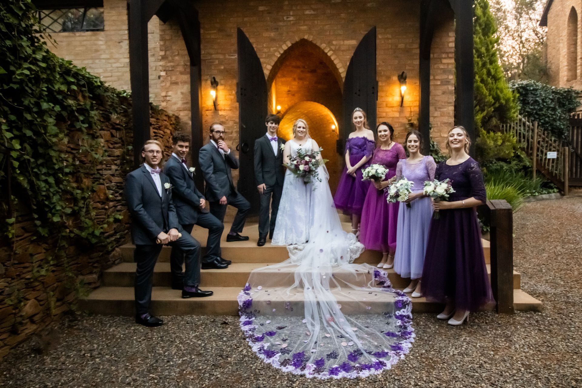 The bride and groom are posing for a picture with their wedding party at Riverside Castle.