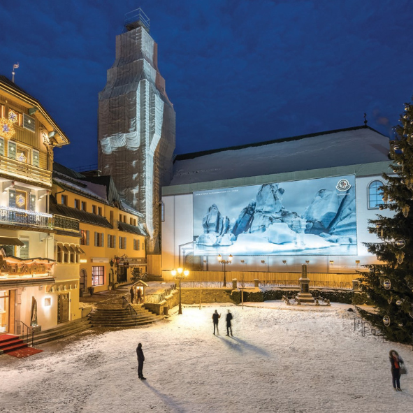 A large painting is projected on the side of a building