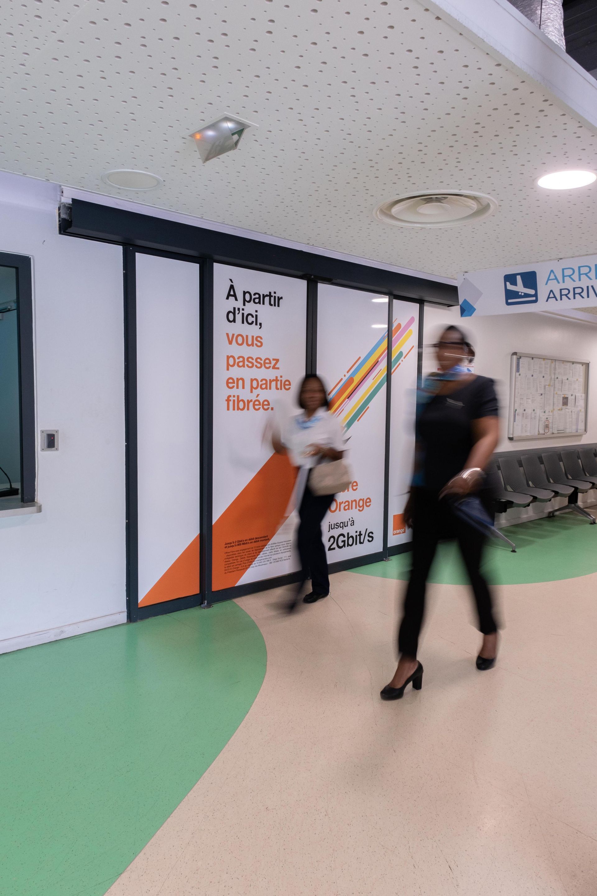 Two women are walking down a hallway in a hospital.