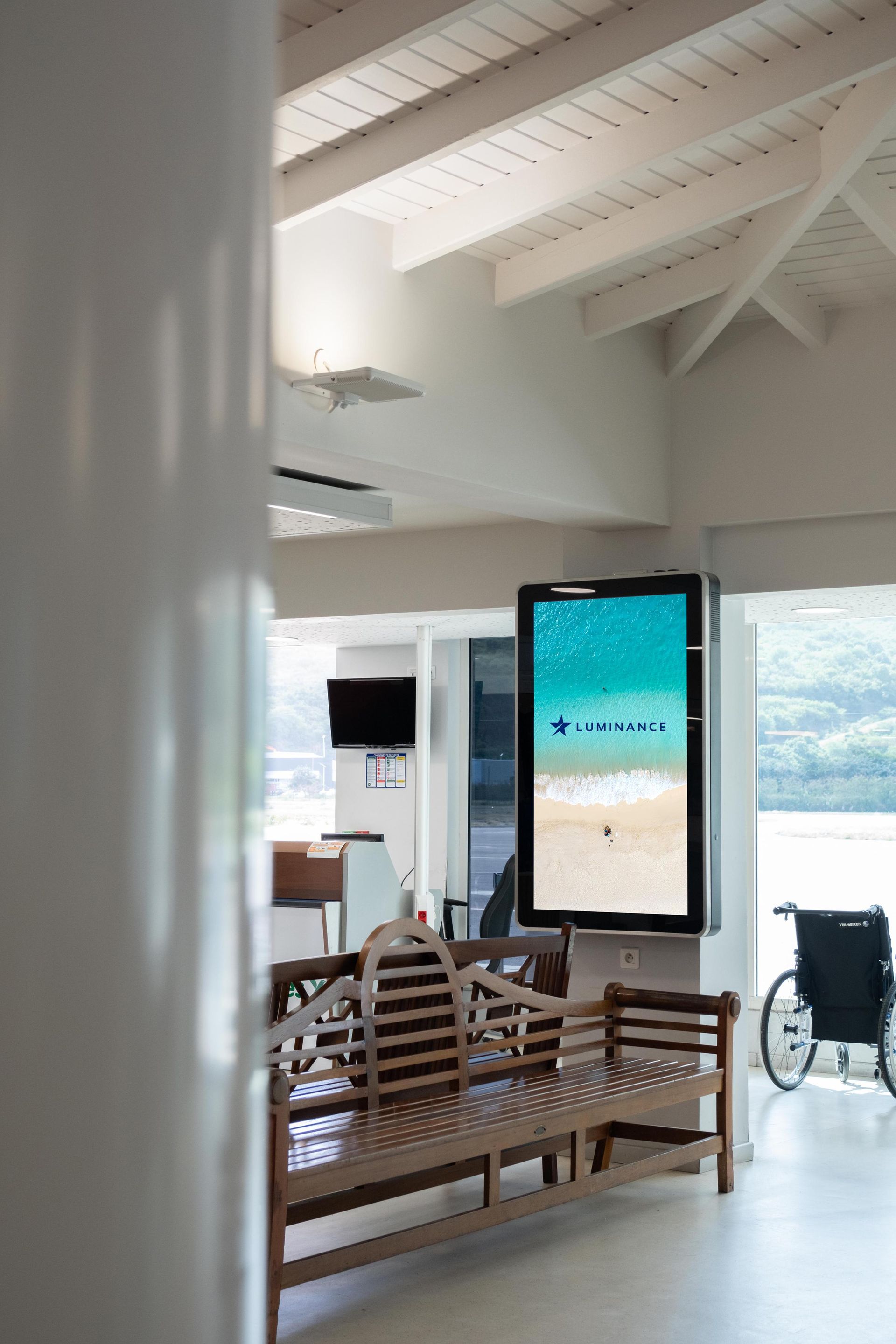 A living room with a bench and a tv on the wall