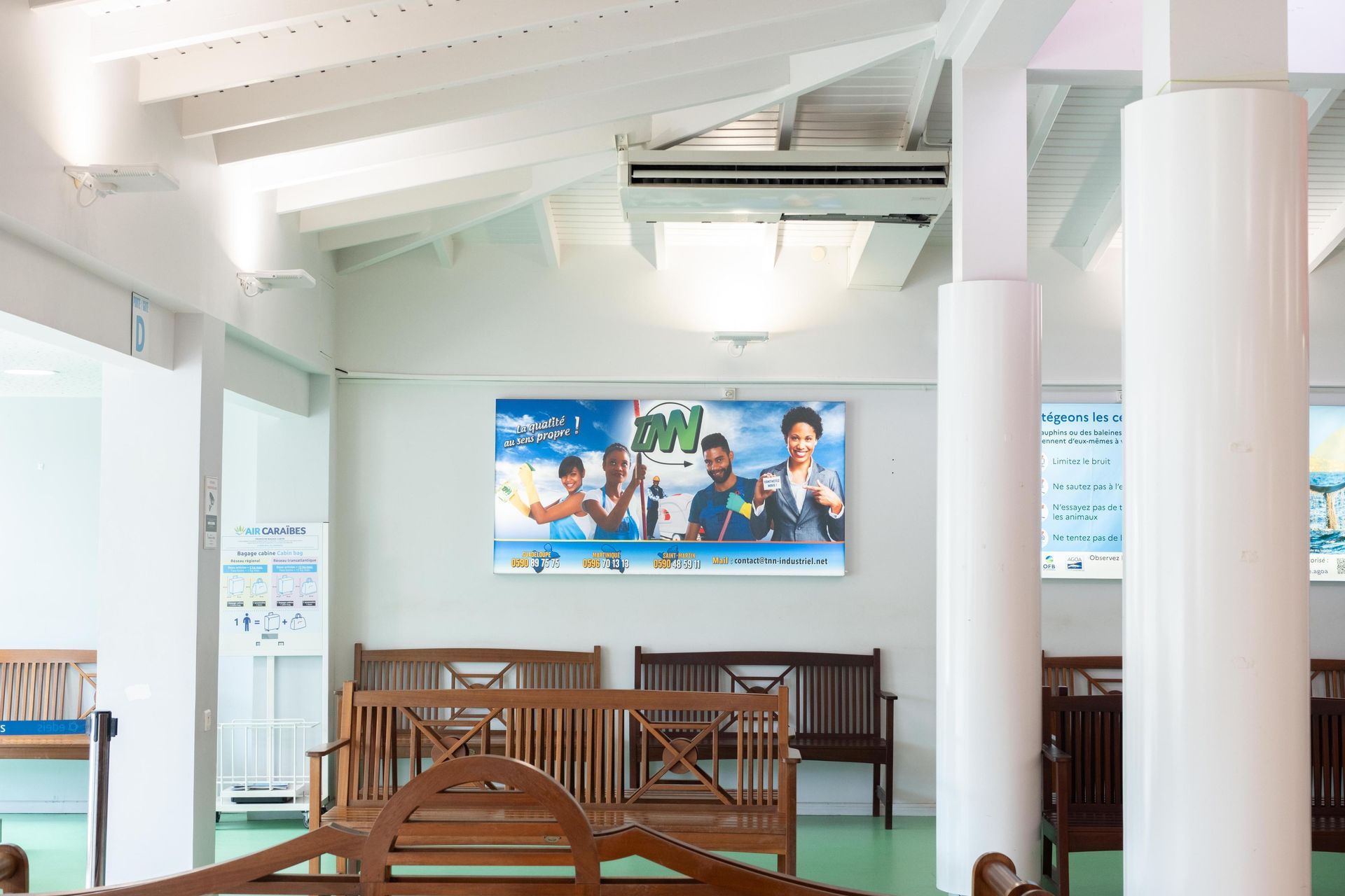 A room with a painting on the wall and benches