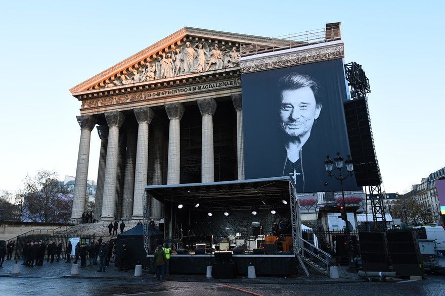 A large building with columns and a stage in front of it.