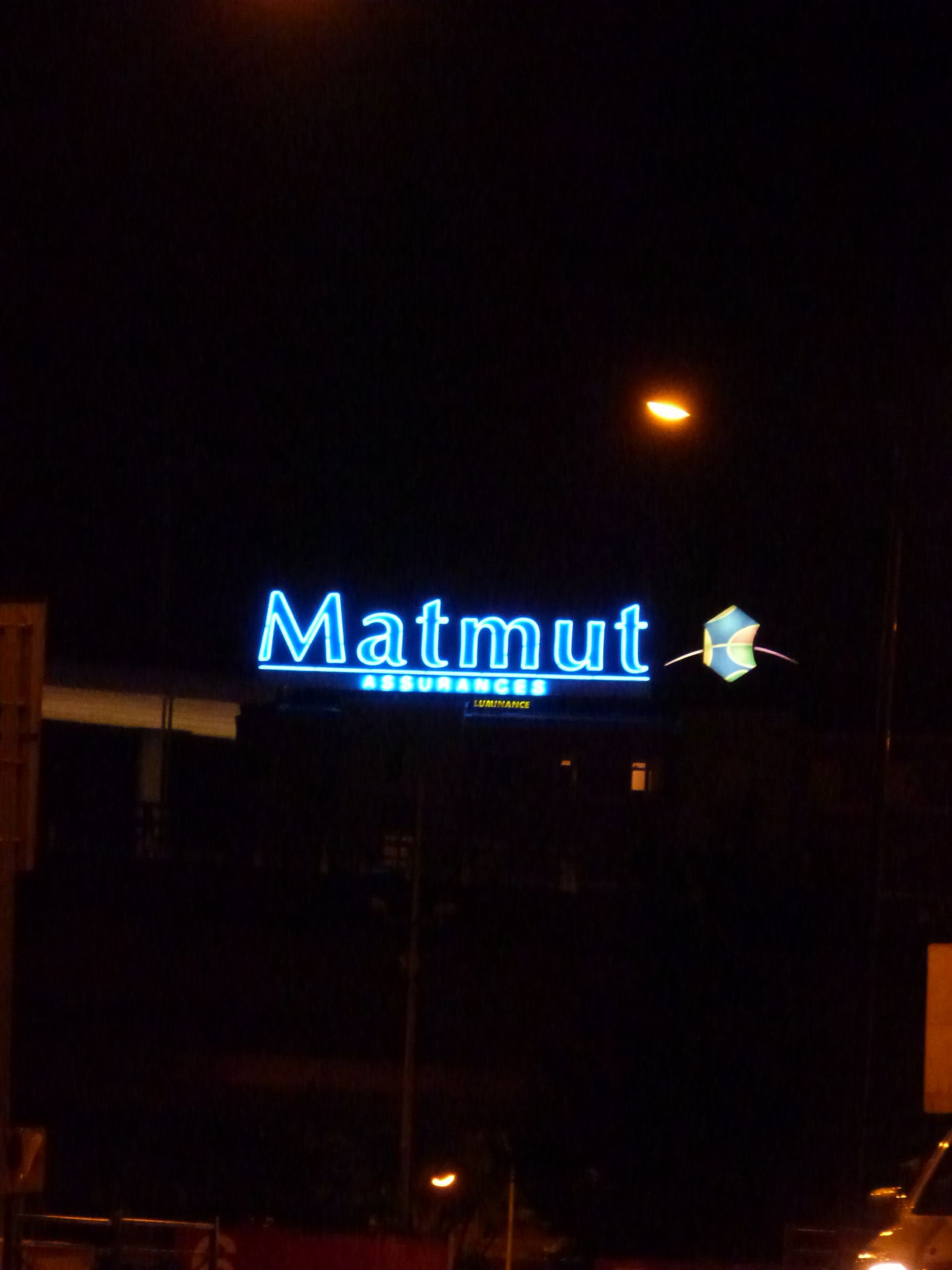 A sign that says matmut is lit up at night