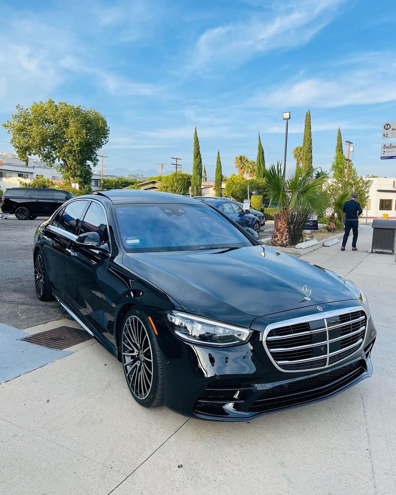 a black mercedes benz s class is parked in a parking lot .