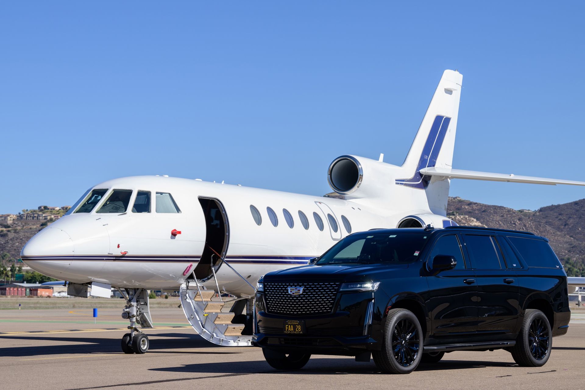 a car is parked next to a private jet on a runway .