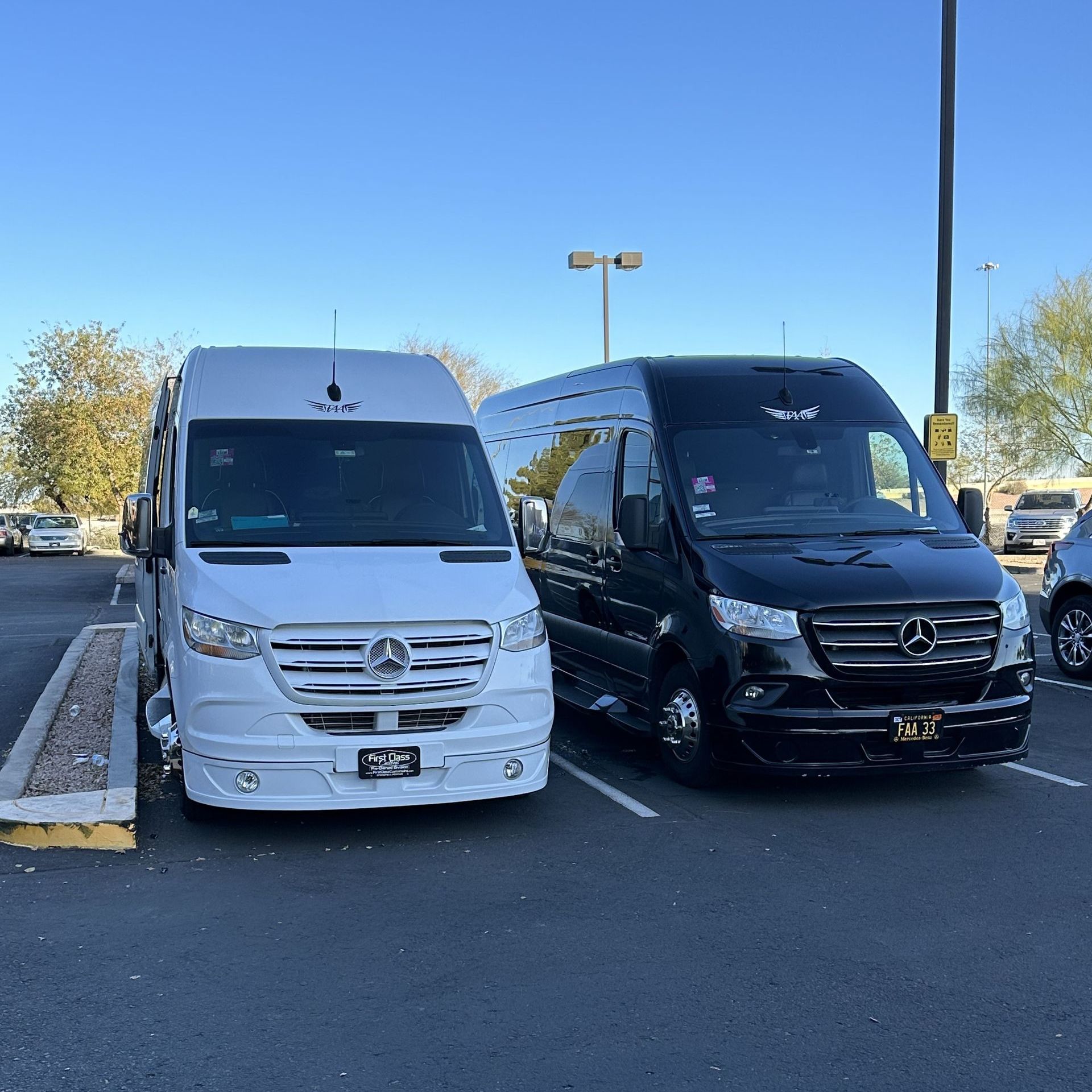 two vans are parked next to each other in a parking lot .