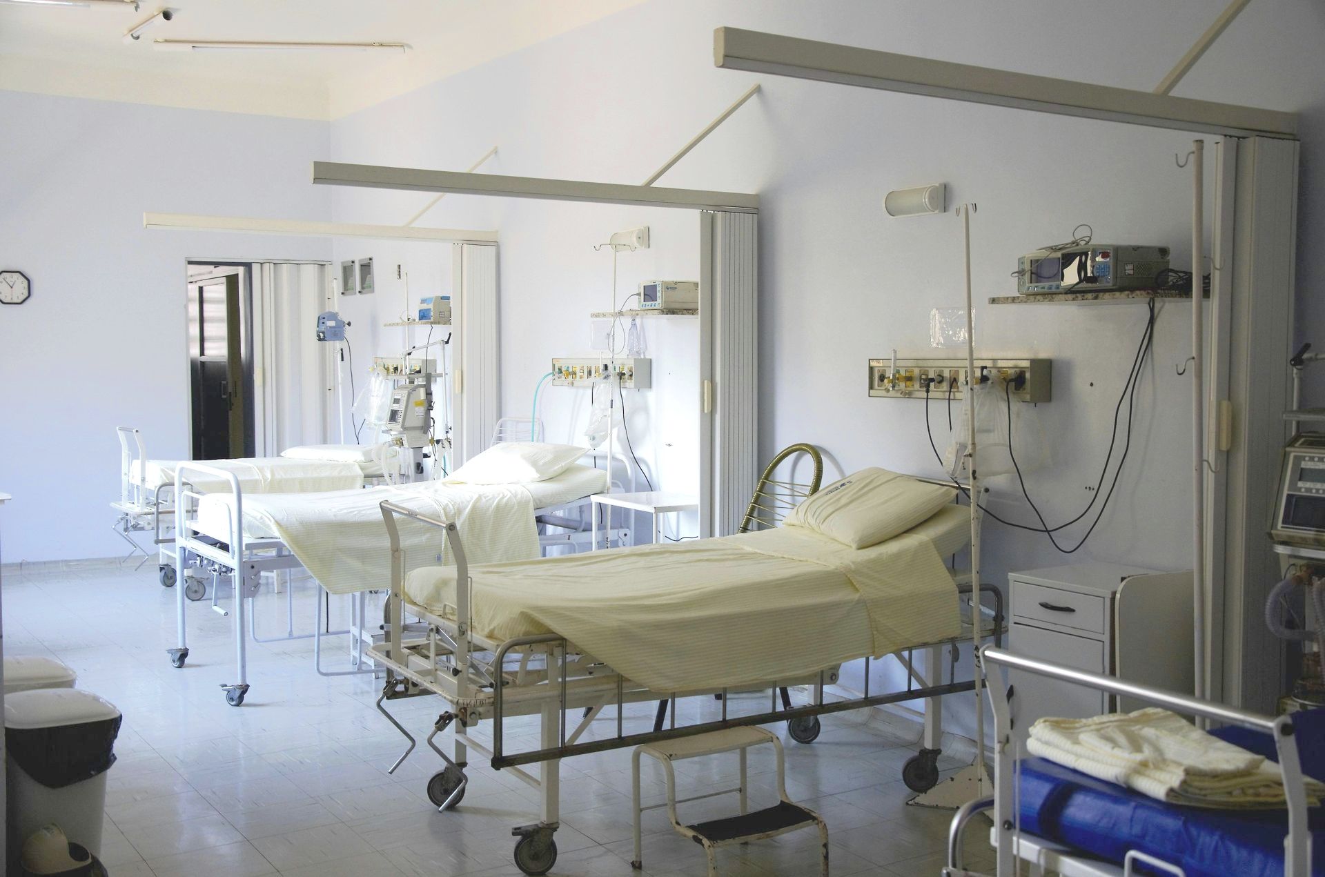 An empty hospital room with a lot of beds