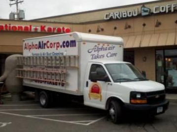 White Alpha Air Corp truck parked near a Caribou Coffee shop and a karate studio.