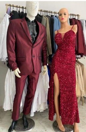 Maniquí con traje burdeos junto a otro con vestido rojo de lentejuelas con abertura alta. Escenario de tienda de ropa.