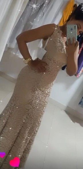 Persona con un vestido ajustado de lentejuelas, tomándose una selfie frente al espejo.