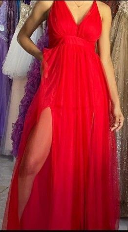 Mujer con vestido de noche rojo con una abertura hasta el muslo.