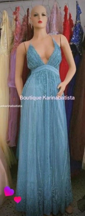 Maniquí con un vestido azul claro con cuentas en una boutique, rodeado de otros vestidos.