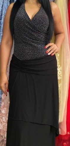 Mujer con un vestido negro de corpiño brillante y falda de varias capas.